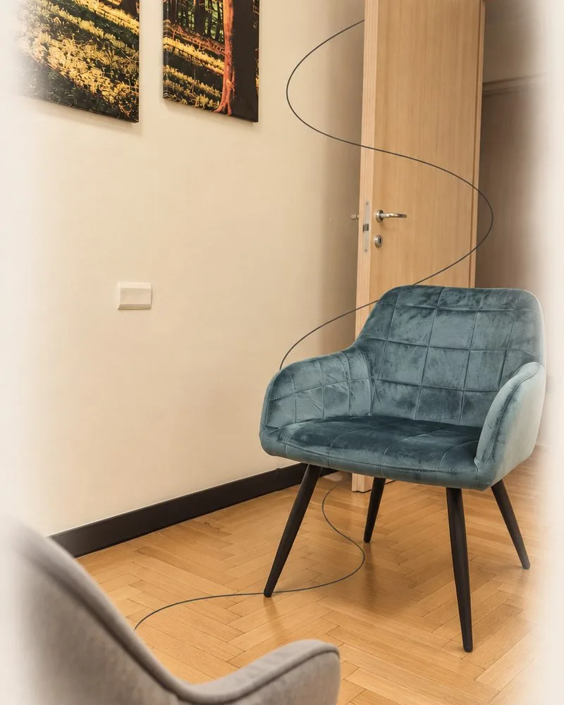Una poltrona verde nello studio, vicino alla porta